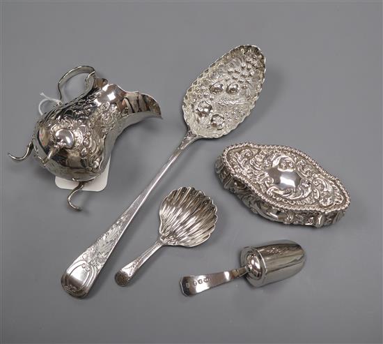 A George III embossed silver cream jug, London 1770, a George III shell-bowl caddy spoon and three other items,